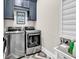 Modern laundry room equipped with front-loading washer and dryer, cabinets, and a folding table at 9407 Venezia Circle, Myrtle Beach, SC 29579