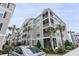 Exterior view of a multilevel condominium building with large screened-in porches and well-manicured landscaping at 126 Ella Kinley Circle # 401, Myrtle Beach, SC 29588