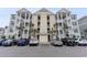 Inviting three-story condo building showcasing stacked porches and well-maintained landscaping, along with convenient parking spaces at 126 Ella Kinley Circle # 401, Myrtle Beach, SC 29588