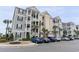 Exterior facade of a multilevel condo building with exterior stairwells surrounded by landscaping and parking spaces at 126 Ella Kinley Circle # 401, Myrtle Beach, SC 29588