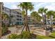 Relaxing pool area with tables, chairs, palm trees, and lounge chairs next to a gray condo building at 126 Ella Kinley Circle # 401, Myrtle Beach, SC 29588