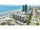 Beautiful aerial view of an oceanfront condo building with a beach, turquoise water, and a parking area at 1310 N Waccamaw Dr. # 211, Garden City Beach, SC 29576