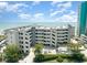 Exterior view of a condo building near the beach with palm trees, a parking area, and balconies at 1310 N Waccamaw Dr. # 211, Garden City Beach, SC 29576
