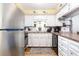 Well-lit kitchen featuring white cabinets, stainless steel fridge, and modern appliances at 1310 N Waccamaw Dr. # 211, Garden City Beach, SC 29576