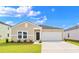 Charming single-story home with a well-manicured lawn and attached two-car garage under a blue sky at 219 Warner Crossing Way, Loris, SC 29569
