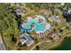 An aerial view shows a large community pool with palm trees and blue umbrellas at 2250 Heritage Loop, Myrtle Beach, SC 29577