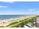 A sunny beach with colorful umbrellas, vegetation, and blue ocean waters at 3000 N Ocean Blvd. # 729, Myrtle Beach, SC 29577