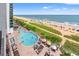 Aerial view of a pool, chairs, and beach with bright colorful umbrellas at 3000 N Ocean Blvd. # 729, Myrtle Beach, SC 29577