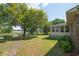 Spacious backyard with mature trees, view of pond, and the back exterior of home at 391 Waterford Dr., Georgetown, SC 29440