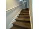 Carpeted staircase featuring a white railing and white walls at 4701 N Kings Hwy. # 19, Myrtle Beach, SC 29579