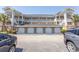 Exterior view of garages beneath condo featuring brick facade and white garage doors at 4823 Orchid Way # 2-203, Myrtle Beach, SC 29577