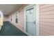 Exterior walkway to condo entrance featuring neutral siding and a storm door at 4823 Orchid Way # 2-203, Myrtle Beach, SC 29577