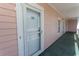 Exterior walkway to condo entrance featuring neutral siding and a storm door at 4823 Orchid Way # 2-203, Myrtle Beach, SC 29577