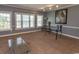 Bright living room with large windows and a modern glass table, complemented by neutral decor at 4823 Orchid Way # 2-203, Myrtle Beach, SC 29577
