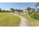 A community pool with a white fence, lounge chairs, and a winding walkway surrounded by greenery at 4823 Orchid Way # 2-203, Myrtle Beach, SC 29577