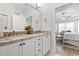 Bright bathroom features double sinks, granite counters, white cabinets, and door to bedroom at 5000 Azul Loop, Myrtle Beach, SC 29579