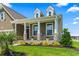 Charming home featuring a cozy front porch with stone accents, green lawn, and manicured landscaping at 5000 Azul Loop, Myrtle Beach, SC 29579