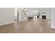 Open-concept living room flows into a white kitchen, featuring a fireplace and wood flooring at 5000 Azul Loop, Myrtle Beach, SC 29579