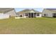 A well-maintained backyard with green grass, a screened-in porch, and an outdoor grilling area at 541 Miromar Way, Myrtle Beach, SC 29588