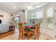 Bright dining area with wooden table and chairs, leading to the living room and featuring large windows at 541 Miromar Way, Myrtle Beach, SC 29588