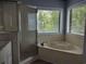 Bathroom with large soaking tub and window to outside, next to glass shower stall at 69 Sea Level Loop, Pawleys Island, SC 29585
