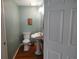 Cozy half-bathroom with pedestal sink and hardwood floors at 69 Sea Level Loop, Pawleys Island, SC 29585