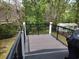 Large deck with black metal railing overlooking green trees and shed at 69 Sea Level Loop, Pawleys Island, SC 29585