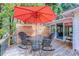 Outdoor deck with seating and a bright red umbrella and a partial view of the sun room at 834 Holly Sands Blvd., Little River, SC 29566