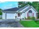 Charming single-story home with a white brick facade, red shutters, and a well-maintained lawn and a two car garage at 834 Holly Sands Blvd., Little River, SC 29566