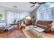 Cozy living room with a plush sofa, wooden furniture, area rug, and a large window with sheer curtains at 834 Holly Sands Blvd., Little River, SC 29566