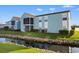 Exterior of a blue condo building with a flowing stream, screened-in porch, and well-maintained landscaping at 8835 Chandler Dr. # E, Myrtle Beach, SC 29575