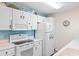 Bright kitchen with white cabinets, modern appliances, and beach-themed décor at 8835 Chandler Dr. # E, Myrtle Beach, SC 29575