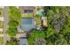 Overhead view of a beautiful home featuring a big yard, a refreshing pool, solar panels, and a detached garage surrounded by mature trees at 1021 Myrtle Dr., Surfside Beach, SC 29575