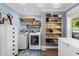 A well-organized laundry room featuring a washer, dryer, and custom wood shelving at 1021 Myrtle Dr., Surfside Beach, SC 29575
