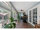 Bright sunroom with floor-to-ceiling windows, wood floors, and a ceiling fan, perfect for a home office or relaxation area at 1021 Myrtle Dr., Surfside Beach, SC 29575