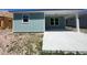 Back patio of a light blue house with a concrete slab and covered area at 1213 Lady Bird Way, North Myrtle Beach, SC 29582