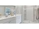 Modern bathroom with double sinks, white cabinets, and a stand-up shower with built-in shelves at 224 Warner Crossing Way, Loris, SC 29569