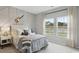 Stylish bedroom features a custom accent wall, two large windows, and neutral decor at 224 Warner Crossing Way, Loris, SC 29569