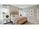 Bright bedroom with a wicker bed frame, patterned lamps, and neutral colors at 224 Warner Crossing Way, Loris, SC 29569