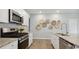 Modern kitchen featuring stainless steel appliances, granite countertops, and stylish backsplash at 224 Warner Crossing Way, Loris, SC 29569