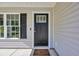 Close-up of front door showcasing modern hardware, sidelight window and neutral siding at 3096 Hugo Rd., Conway, SC 29527