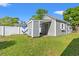 Home exterior featuring gray siding, white trim, green grass, and a privacy fence at 319 Sparrow Dr., Surfside Beach, SC 29575