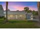 Captivating home with a screened porch, garage, and subtle lighting against a beautiful sunset backdrop at 319 Sparrow Dr., Surfside Beach, SC 29575