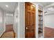 Hallway with wood-look floors, white walls, and a natural wood door to a storage closet at 319 Sparrow Dr., Surfside Beach, SC 29575
