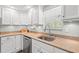 Clean and stylish kitchen with white cabinetry, stainless steel dishwasher, and ample counter space at 319 Sparrow Dr., Surfside Beach, SC 29575