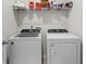 Modern laundry room featuring a side-by-side washer and dryer with shelving for storage above at 3549 Bells Lake Circle, Longs, SC 29568