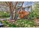 Charming stilted home with a wooden staircase leading to a screened porch, surrounded by lush trees and greenery at 4520 Hedrick St., North Myrtle Beach, SC 29582