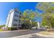 Multi-story condo building with well-manicured lawns, mature trees, and ample parking at 4560 Greenbriar Dr. # 306B, Little River, SC 29566