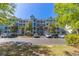 Low-rise condominium building with balconies, mature trees, and ample parking at 4560 Greenbriar Dr. # 306B, Little River, SC 29566