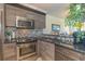 Modern kitchen featuring wooden cabinets, backsplash, stainless steel appliances and granite countertop at 4560 Greenbriar Dr. # 306B, Little River, SC 29566